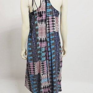 May include: A blue, pink, and black patterned maxi dress with a halter neckline and a tie at the back.