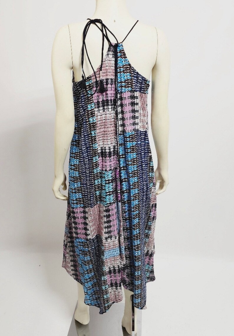 May include: A blue, pink, and black patterned maxi dress with a halter neckline and a tie at the back.