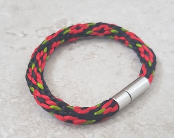 Può includere: Un braccialetto intrecciato rosso, nero e verde con una chiusura magnetica argentata.