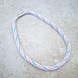 May include: A blue, white, and pink braided lanyard with a silver clasp.
