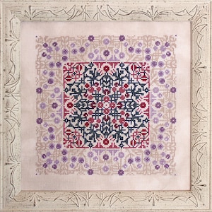May include: A framed cross-stitch design featuring a geometric pattern in shades of red, purple, and black. The design is surrounded by a border of smaller purple and white circles.