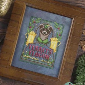 May include: Cross-stitch artwork in a wooden frame. The design features a ferret wearing a green hat and collar, with two yellow teapots. Text reads "The Ferret's Flagon, Adventurers Welcome!" in a whimsical font, surrounded by a green border.