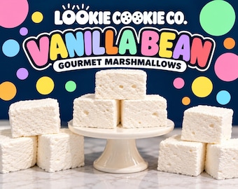 May include: White square marshmallows stacked on a small cream-colored pedestal stand. The background features the text Lookie Cookie Co. Vanilla Bean Gourmet Marshmallows with colorful polka dots on a dark blue backdrop.