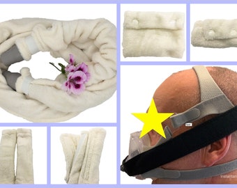 Può includere: Cinturini per la testa in tessuto di pile bianco per una macchina CPAP. I cinturini sono mostrati in diverse configurazioni, tra cui un cerchio completo, due cinturini separati e un cinturino con una tasca. I cinturini sono progettati per fornire comfort e supporto per la maschera CPAP.