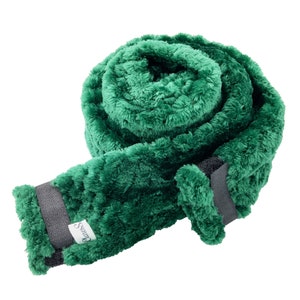Könnte beinhalten: Ein grüner Plüsch-Halswärmer mit einem schwarzen Band und dem aufgedruckten Wort "Snuggles".