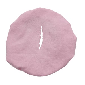 May include: A pink fabric headband with a small hole in the center.