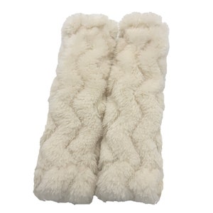 May include: A pair of white fuzzy boot cuffs with a woven pattern.