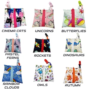 Op de afbeelding: Negen verschillende ritszakjes met verschillende kleurrijke prints. De zakjes zijn gemaakt van stof en hebben een ritssluiting. De prints omvatten katten, eenhoorns, vlinders, varens, raketten, dinosaurussen, wolken, uilen en herfstbladeren.