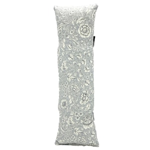 May include: A long, gray pillow with a white floral pattern. The pillow is made of a soft, textured fabric.