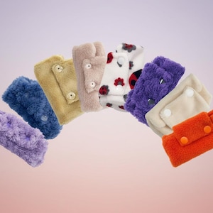 May include: A white ceramic mug with a black handle and the text "But First, Coffee" in a bold, black font. The mug is set against a blurred background, suggesting a cosy setting.