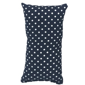 May include: A navy blue pillow with white polka dots. The pillow is rectangular and has a soft, plush texture.
