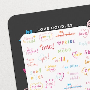 Pode incluir: Uma folha de adesivos coloridos com várias frases e desenhos, incluindo "love", "good vibes", "no bad vibes", "girl power", "cute but psycho", "yes", "wild", "mood", "omg", "pride", "nah", "i believe in me", "no filter", "moon child", "psycho", "yummy!" e "flower child".