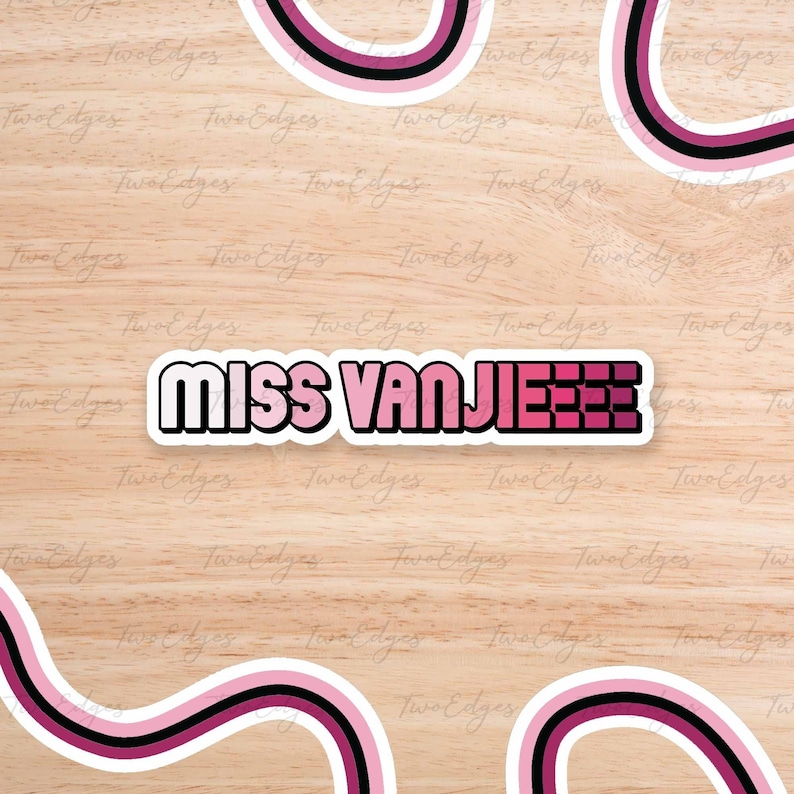 Pode incluir: Um adesivo rosa e branco com o texto "MISS VANJIEEE" em uma fonte em negrito e em blocos. O adesivo est&aacute; em um fundo de madeira marrom claro.