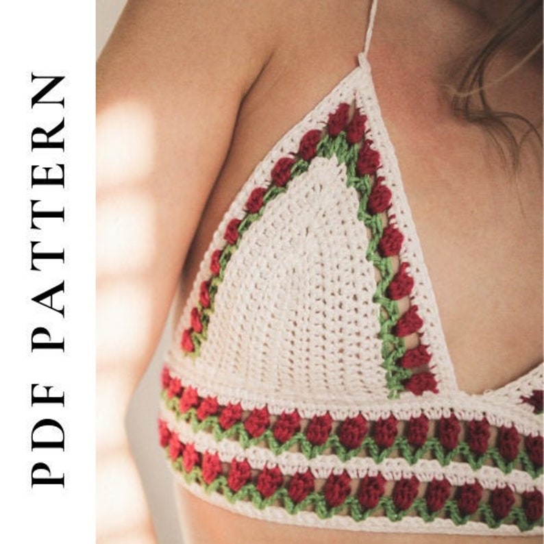 May include: A white crochet top with red and green floral detailing. The top features a triangle shape with a halter neck design. The text "PDF PATTERN" is visible on the left side of the image.