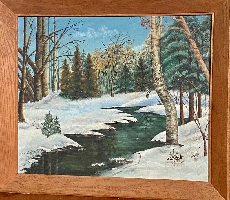 May include: A painting of a winter scene with a winding stream flowing through a snowy forest. The trees are bare and the ground is covered in white snow. The stream is a deep green color and reflects the blue sky above. The painting is framed in a wooden frame.