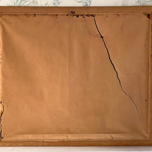 May include: A wooden picture frame with a crack in the brown paper backing.