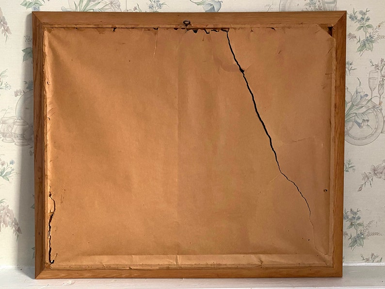 May include: A wooden picture frame with a crack in the brown paper backing.