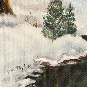 May include: A winter landscape painting with a snowy scene and a small evergreen tree in the foreground. The painting is signed "G.M. Taylor" in the lower left corner.