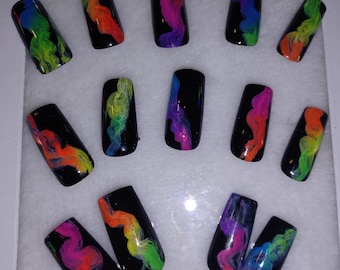 May include: Set of ten false nails with a black base and rainbow swirl design.