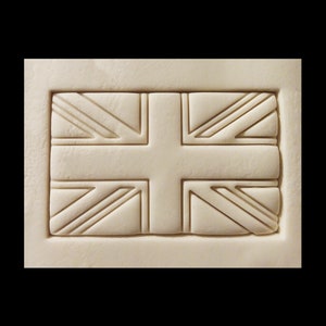 May include: A white rectangular plaque with a raised, embossed design of the Union Jack flag.