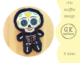 Puede incluir: Diseño bordado para un juguete de peluche con forma de esqueleto con una cara de calavera de azúcar del Día de Muertos. El diseño es en azul, blanco, verde, amarillo y rojo. El texto "ITH stuffie design" y "GK applique" es visible en la imagen. El texto "5 tamaños" también es visible en la imagen.