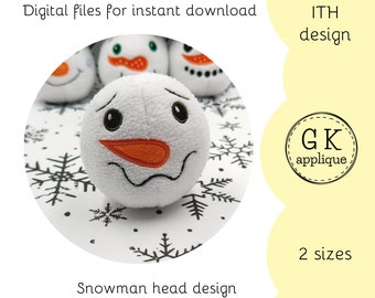 May include: A white snowman head with a stitched orange nose and black eyes. The snowman head is on a white background with black snowflakes. The text "ITH design" and "GK applique" are in the image. The text "2 sizes" is also in the image.