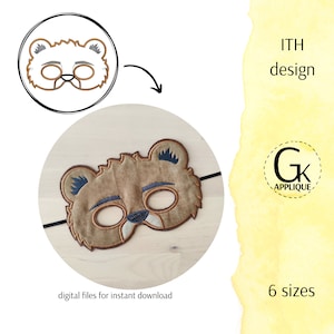 May include: A brown bear mask with black eyes and a brown nose. The mask is made of felt and has a black elastic band. The mask is on a wooden surface. The text "ITH design" and "6 sizes" is visible in the image.