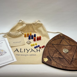 May include: A wooden game board with a six-pointed star design, a small bag of game pieces, and a set of instructions. The game board is brown and has a brass inlay. The game pieces are red, blue, yellow, and orange. The instructions are titled "Aliyah: The King's Game..."
