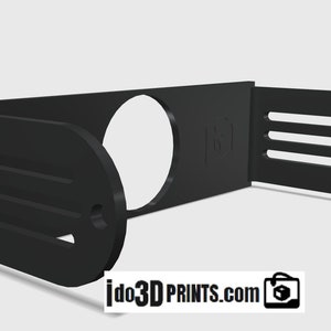 May include: Black plastic 3D printed wall mount with a circular cutout and slots on the sides. The mount is designed to hold a camera or other device.