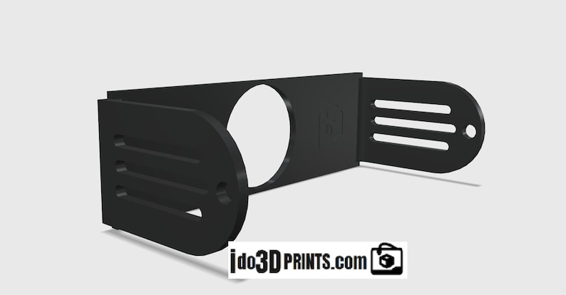 May include: Black plastic 3D printed wall mount with a circular cutout and slots on the sides. The mount is designed to hold a camera or other device.