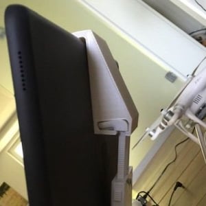 May include: A white 3D printed tablet stand with a black tablet attached. The stand is designed to hold the tablet upright.