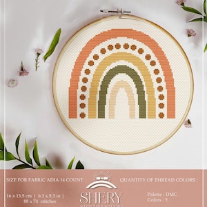 May include: A cross-stitch rainbow design in a wooden embroidery hoop. The rainbow features shades of orange, yellow, and green. The text "SHERY STICHES STUDIO" is visible. The fabric size is 6.3 x 5.3 inches.