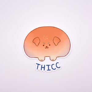 May include: A sticker of a cartoon dog with a round, orange body and the word "THICC" printed below it.