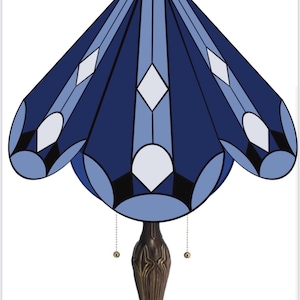 May include: A blue stained glass lamp with a geometric design. The lamp has a brown base and a chain with a gold ball hanging from it.