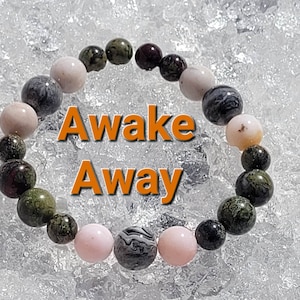 May include: A bracelet made of green, black, and pink beads. The bracelet is on a white background with the words "Awake Away" written in orange.