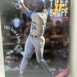 May include: A vintage copy of "The Jr. Stuff" magazine from July 1991, featuring a baseball player in action. The cover includes text that reads "FREE Cards & Griffey Poster Inside!" and "FIRST ISSUE!" The magazine is aimed at kids interested in sports collecting.