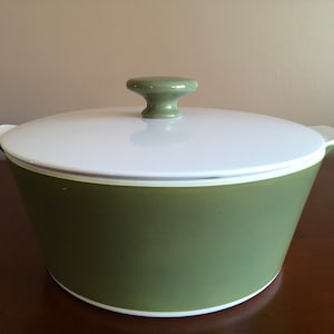 May include: A green ceramic casserole dish with a white lid and a green knob. The dish has a white rim.
