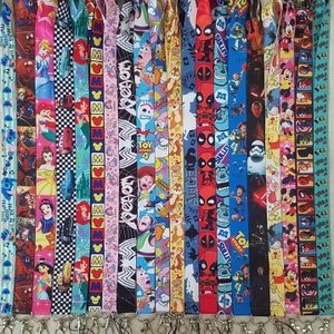 May include: A collection of 20 colorful lanyards featuring various cartoon characters, including Mickey Mouse, Toy Story characters, and Marvel characters like Deadpool. The lanyards are made of a soft, durable material and have a variety of designs.