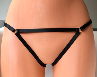 May include: Black lingerie with a triangle shape and two gold rings on the straps.