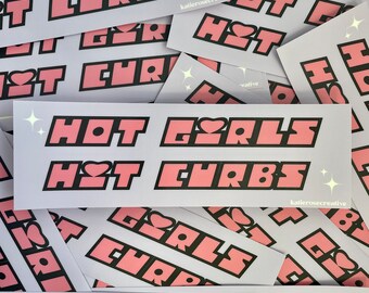 May include: A stack of stickers with the text "Hot Girls Hot Chrb" in pink and black letters on a light purple background. The stickers have a glittery effect.