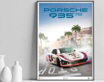 May include: A white Porsche 935/78 race car with red and blue accents drives down a road with palm trees and a sign that says "Hollywood". The car has the number "43" on the side and "Shell" on the back.