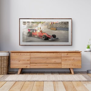 Könnte beinhalten: Ein gerahmtes Foto eines roten Rennwagens, der auf einer Rennstrecke rast. Das Auto ist in Bewegung und hinterlässt eine Rauchspur. Die Strecke ist mit Barrieren gesäumt und im Hintergrund sind Zuschauer zu sehen.