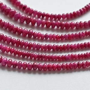 May include: Multiple strands of ruby red gemstone beads, each strand is made of round, smooth beads.