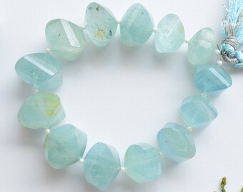 May include: A strand of light blue aquamarine gemstone beads, each bead is faceted and has a unique shape. The beads are strung on a white thread and are tied together with a light blue tassel.