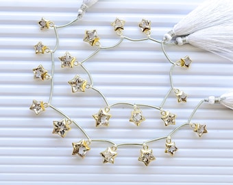 Conjunto de 10 pingentes de quartzo cristal facetado em formato de estrela, banhados a ouro, com engaste em bisel. Pedras preciosas naturais. | 13x13x8 a 8x8x6 mm