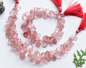 May include: A strand of pink quartz beads with faceted edges. The beads are strung on a silver wire and have a natural, rough texture. The strand is approximately 18 inches long and is perfect for making jewelry.