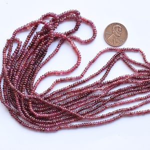 Pu&ograve; includere: Un filo di perle di rubino rosso scuro, di circa 2 mm di diametro, con una lunghezza di 40 cm. Le perle sono infilate su un filo sottile e sono pronte per essere utilizzate per la creazione di gioielli.