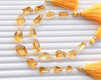 May include: A strand of faceted, golden yellow citrine gemstone beads strung on silver wire with yellow tassel accents.