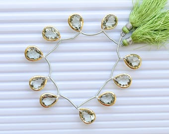 Conjunto de 10 contas de ametista verde facetadas em formato de pera, com acabamento dourado e engaste em bisel, ideais para confecção de joias | 15x13x7 a 15x12x7 mm