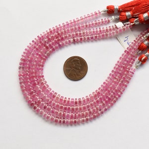 May include: A strand of pink tourmaline beads, with a square shape, strung on a silver thread. The beads are approximately 4mm in size and are displayed on a white background.